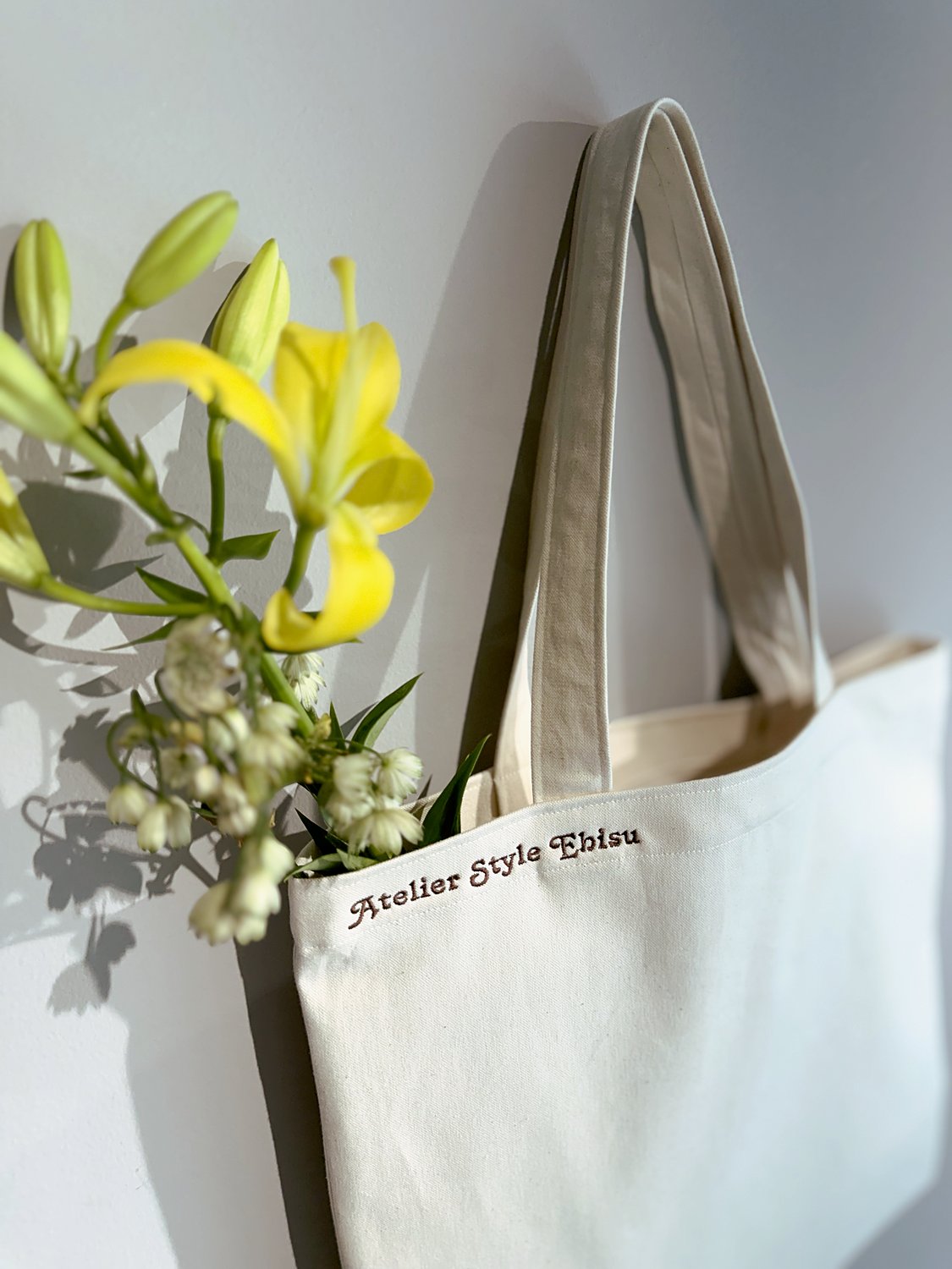 Atelier Style Ebisu のキャンバストートと季節の花